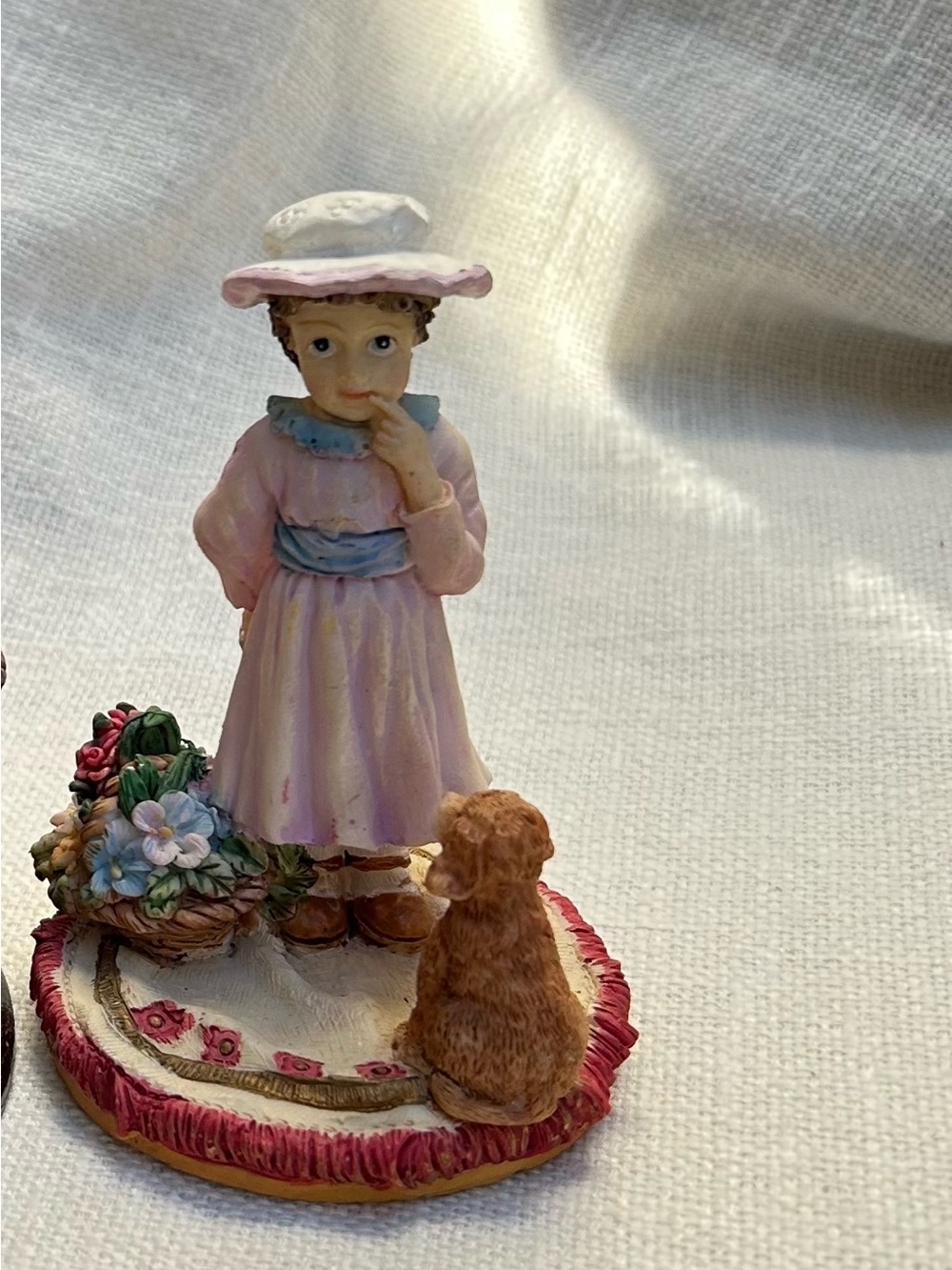 vintage figurine depicting a young girl in a dress and hat next to a small dog